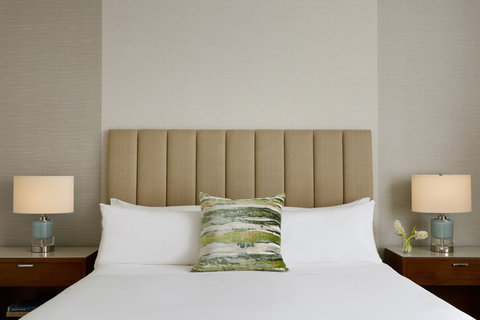 Bedroom with upholstered headboard and pillows.