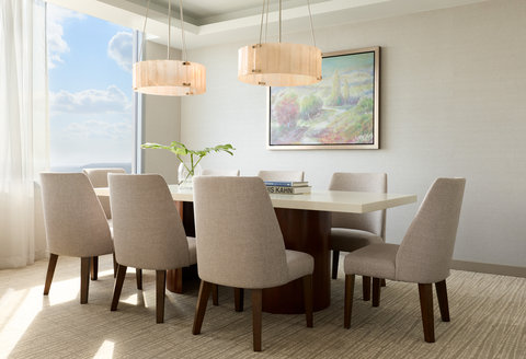Dining room with table, chairs, and large windows.