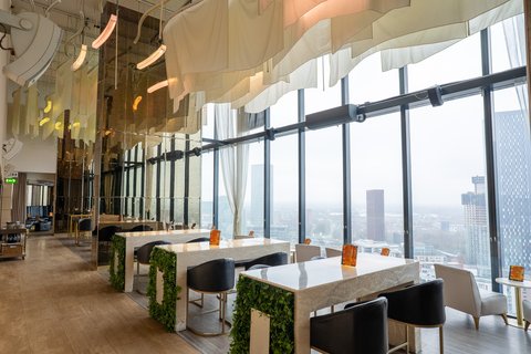 Unwind with a drink in our bar, featuring panoramic skyline views.