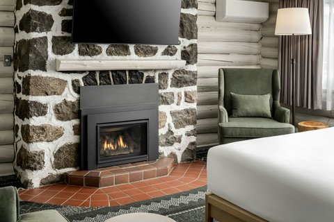 Stone fireplace and lounge seating in guestroom.