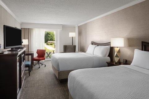Enjoy pool views from the balcony in our two queen guest room.