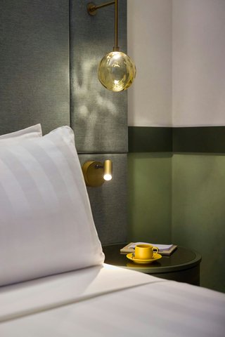 Bedside lighting and textures in the guest room.